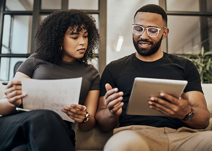 Couple sitting on a couch reviewing their 401(k) plan options.